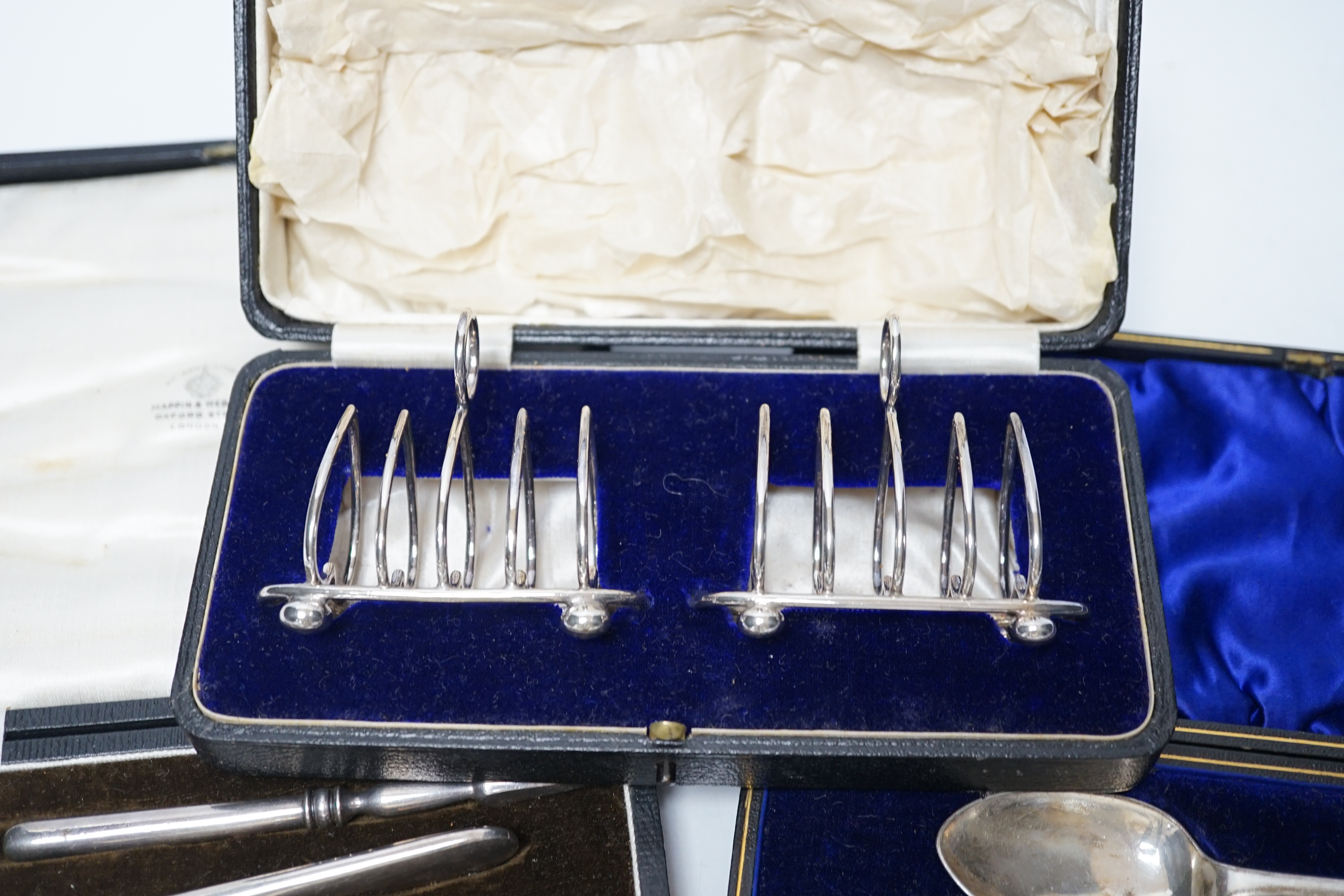 Thirteen assorted cased silver sets, including two sets of six handled tea knives, Leicester and Pudsey replica spoons, two matched sets of napkin rings, single spoon, christening trio, two sets of teaspoons, pair of toa